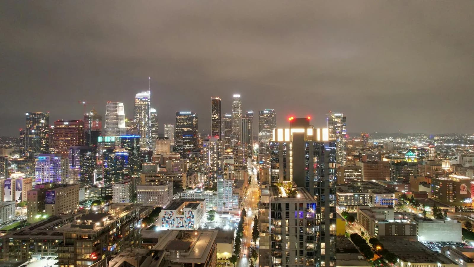 A breathtaking aerial view of Los Angeles skyscrapers illuminated against the night sky, showcasing the vibrant cityscape.