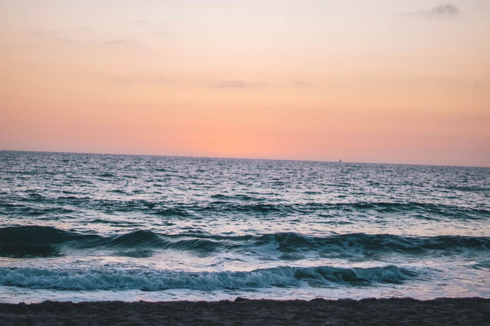 Calm waves and a vibrant sky at sunset on Hermosa Beach, CA.
