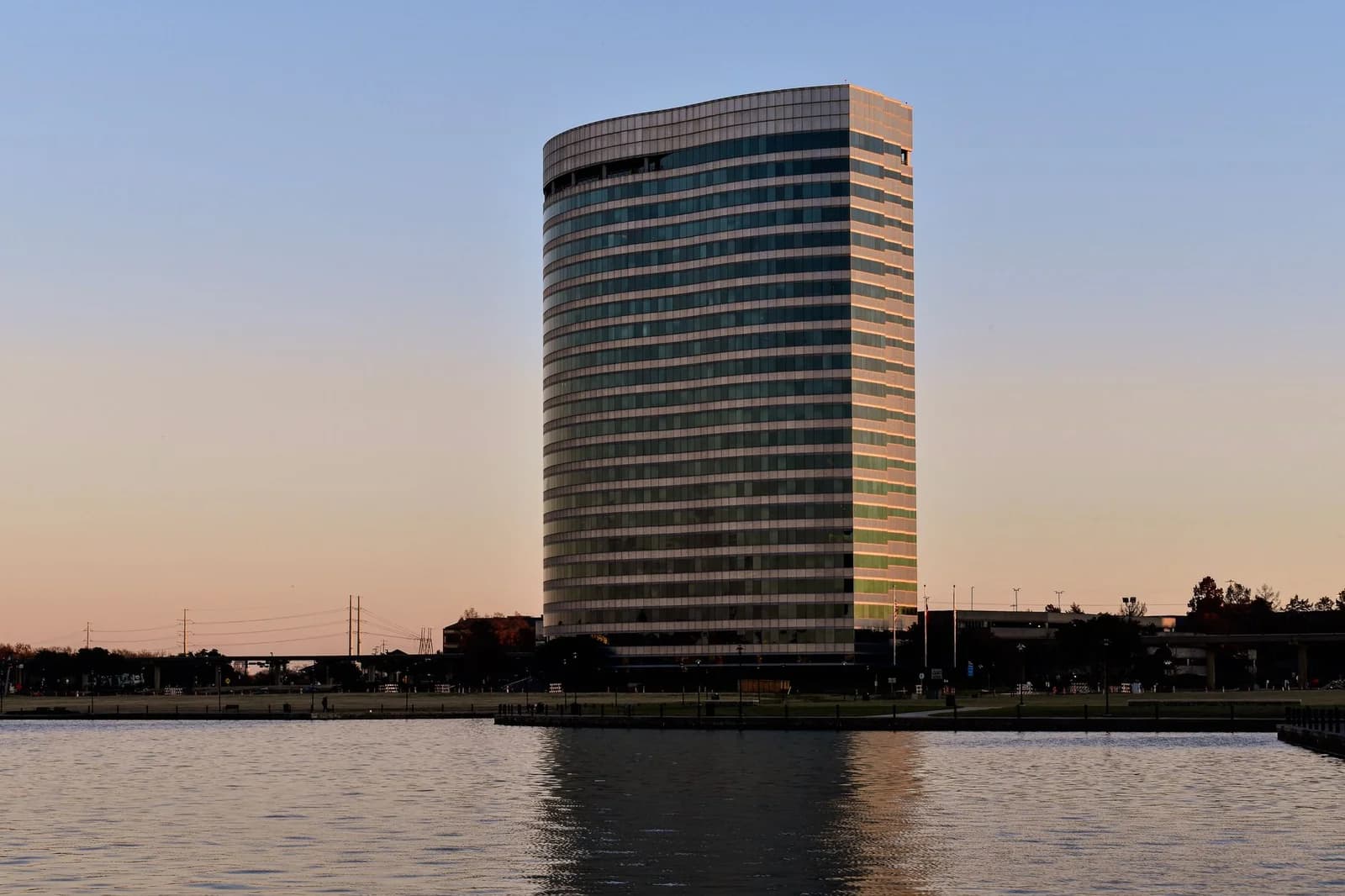 A sleek office building reflected on a lake at sunset in Irving, Texas, USA.