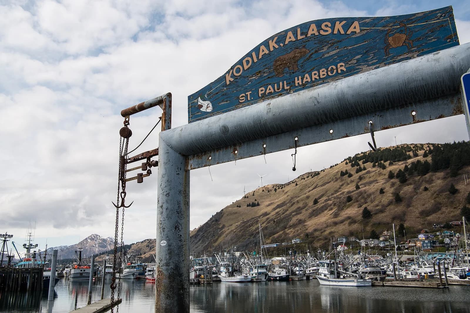 The St. Paul Harbor sign in Kodiak, Alaska with the fishing fleet moored behind it