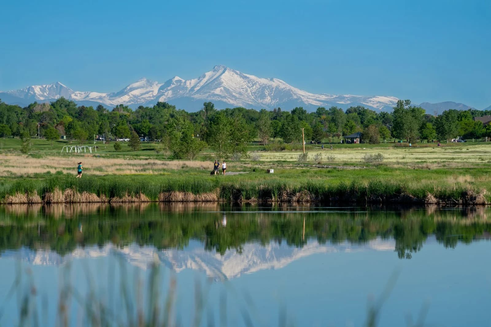 Beautiful landscape of mountains reflecting on a serene lake surrounded by lush greenery.