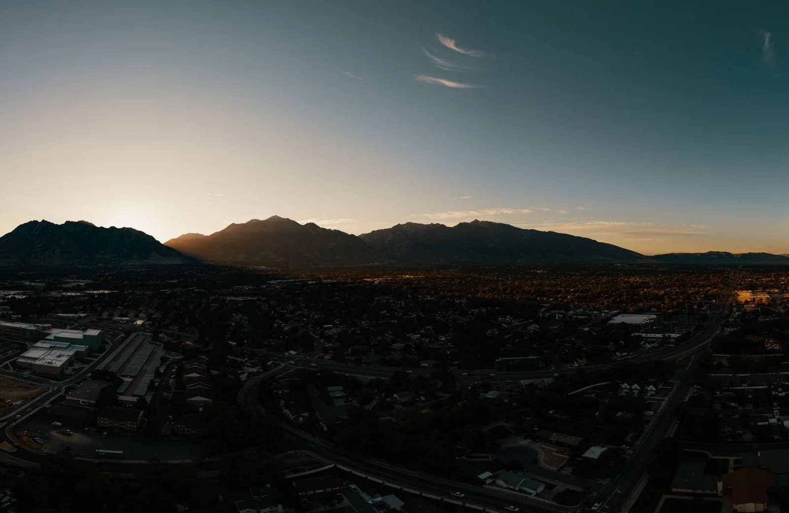 A breathtaking aerial view of Midvale, Utah at sunset with mountains in the background.