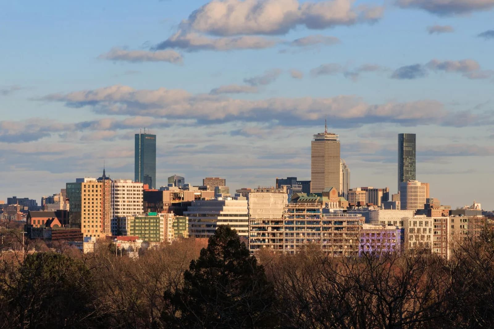 Skyline view of Cambridge, Massachusetts with Boston cityscape in the background under a clear sky.