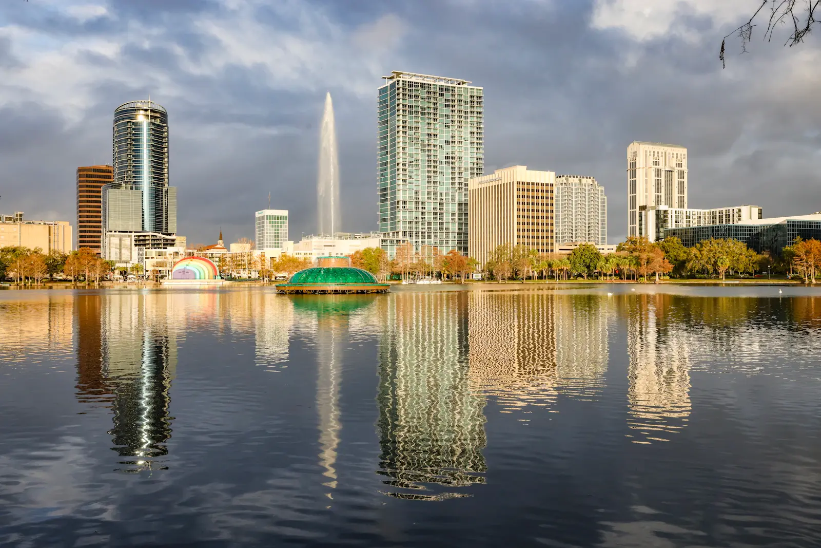 Lake Eola fountain and downtown Orlando skyline reflected in the water under dramatic clouds