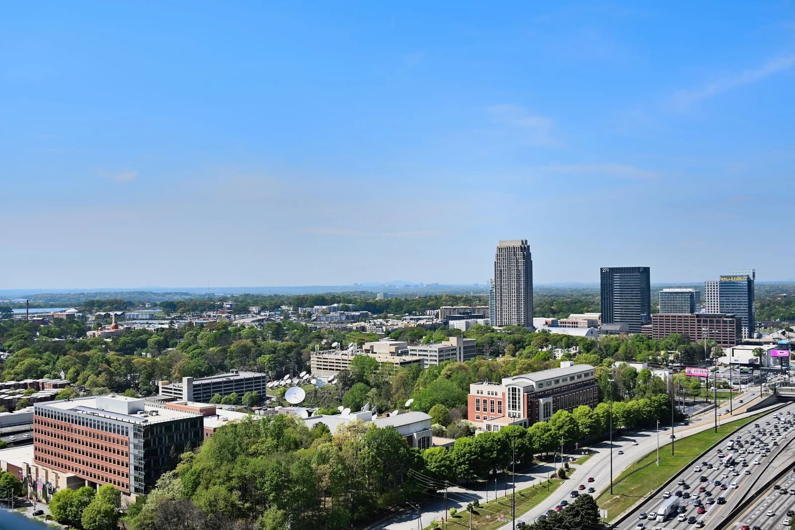 Vibrant aerial cityscape of Atlanta, Georgia showcases the urban skyline under a clear blue sky.