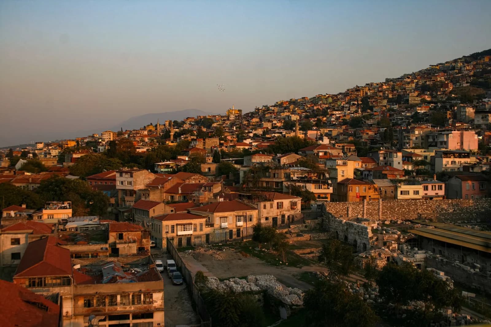 Scenic aerial view of İzmir's residential area during golden hour with hillside houses.