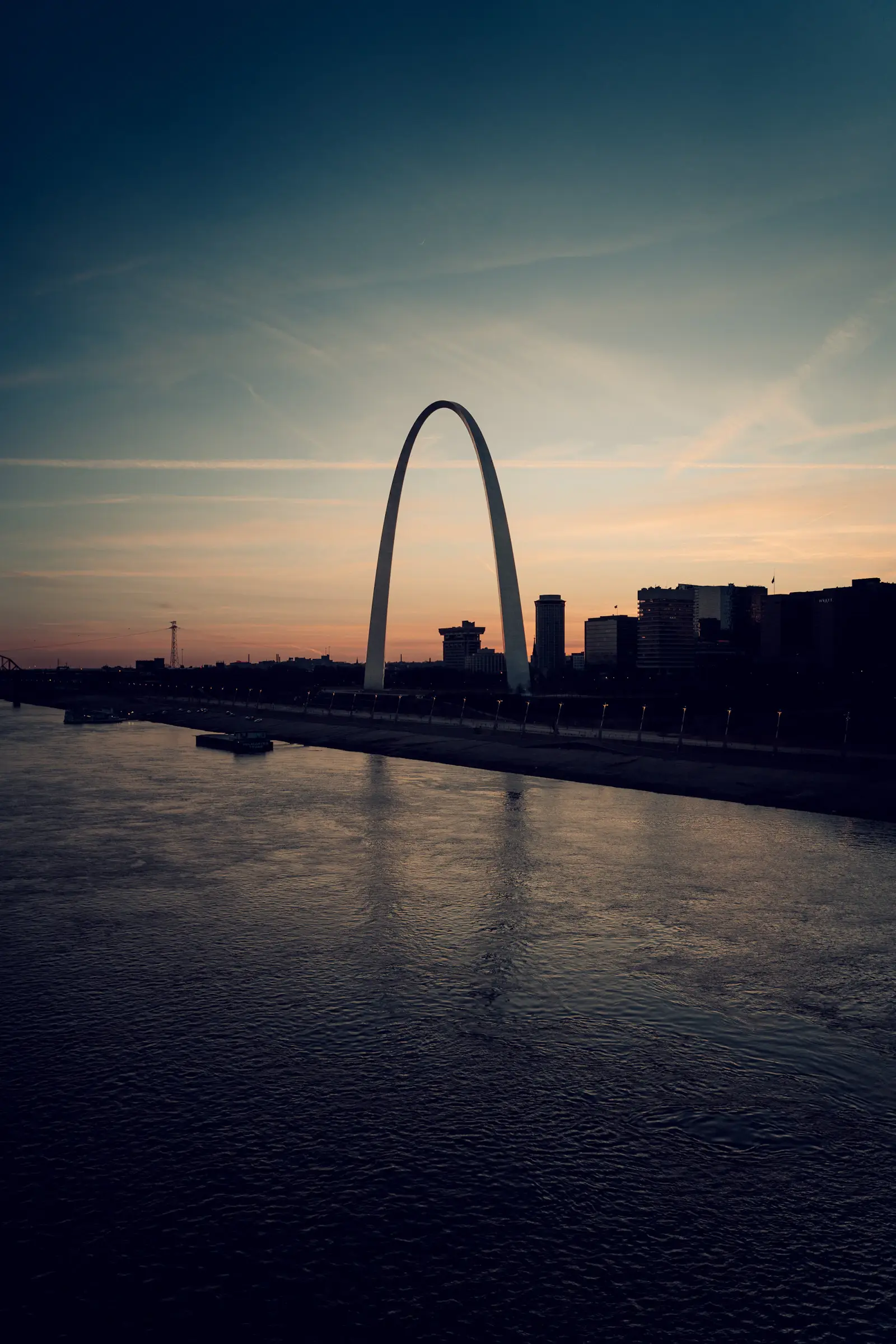 St. Louis Missouri skyline at sunset featuring the Gateway Arch along the Mississippi River