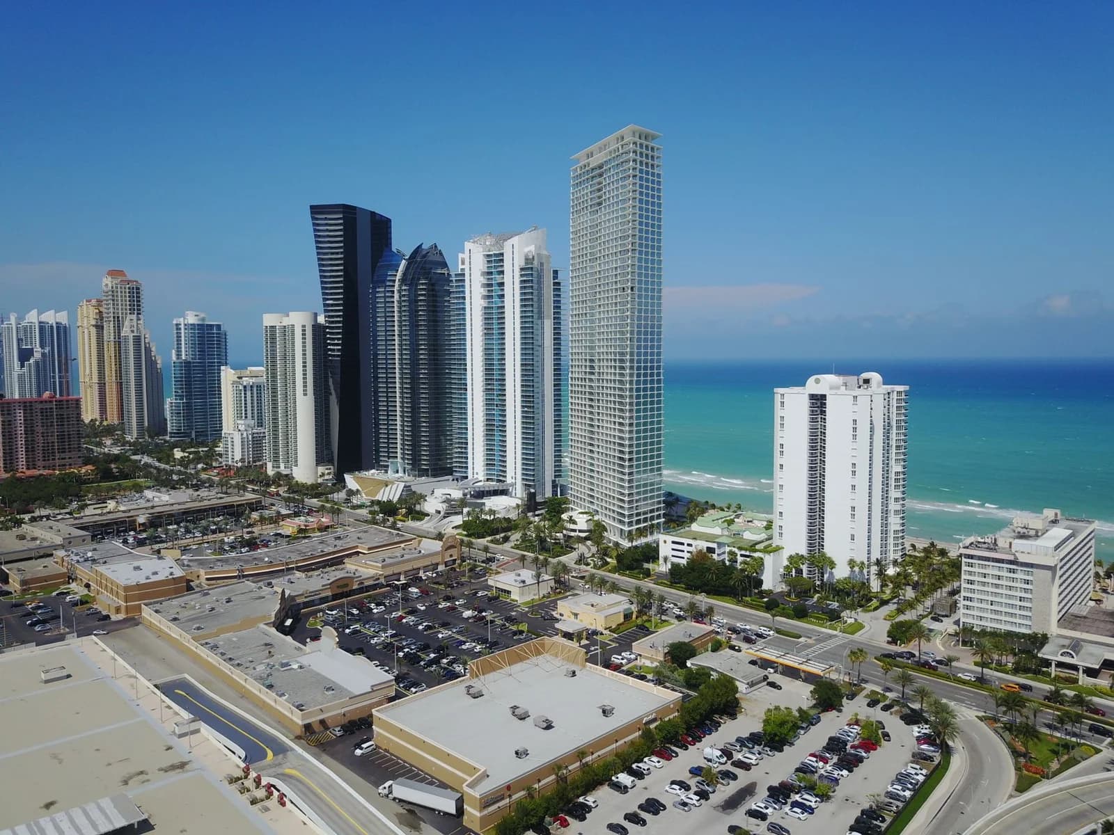 Drone shot of Sunny Isles Beach, FL skyline with ocean and skyscrapers.