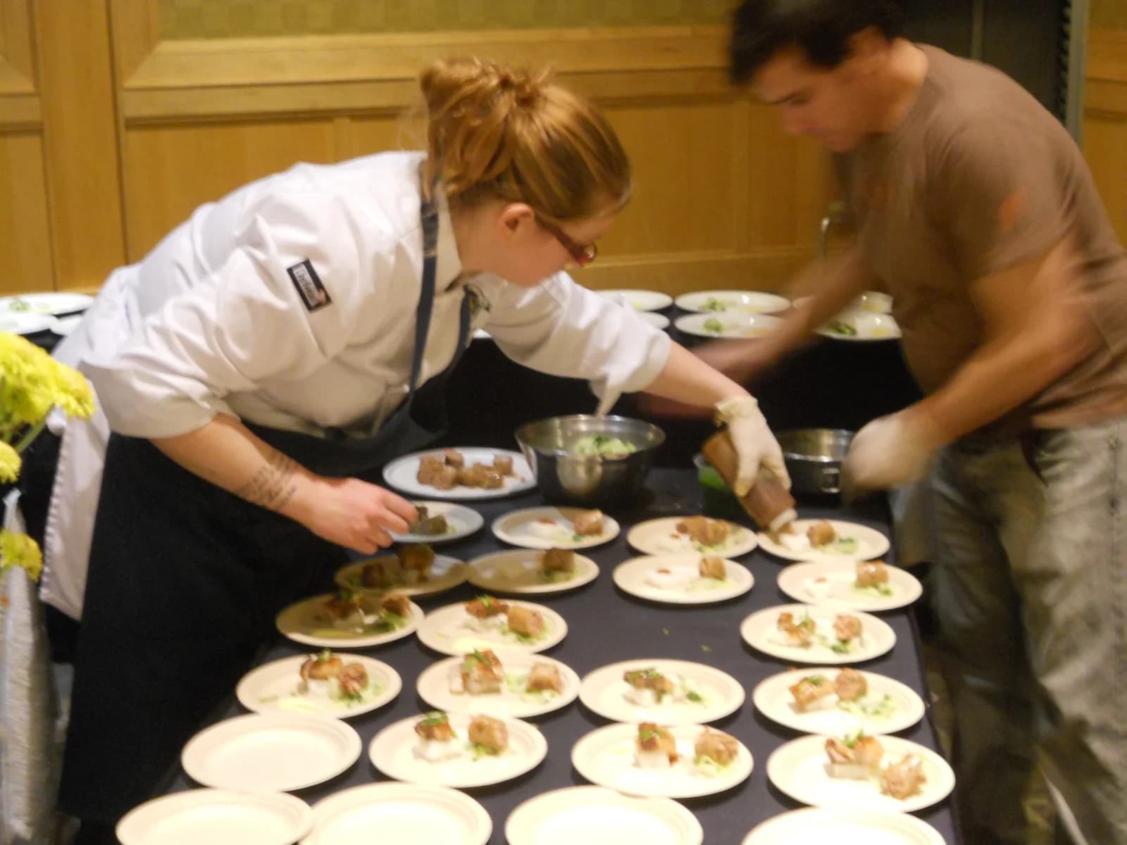 Catering team plating individual dishes for a corporate event