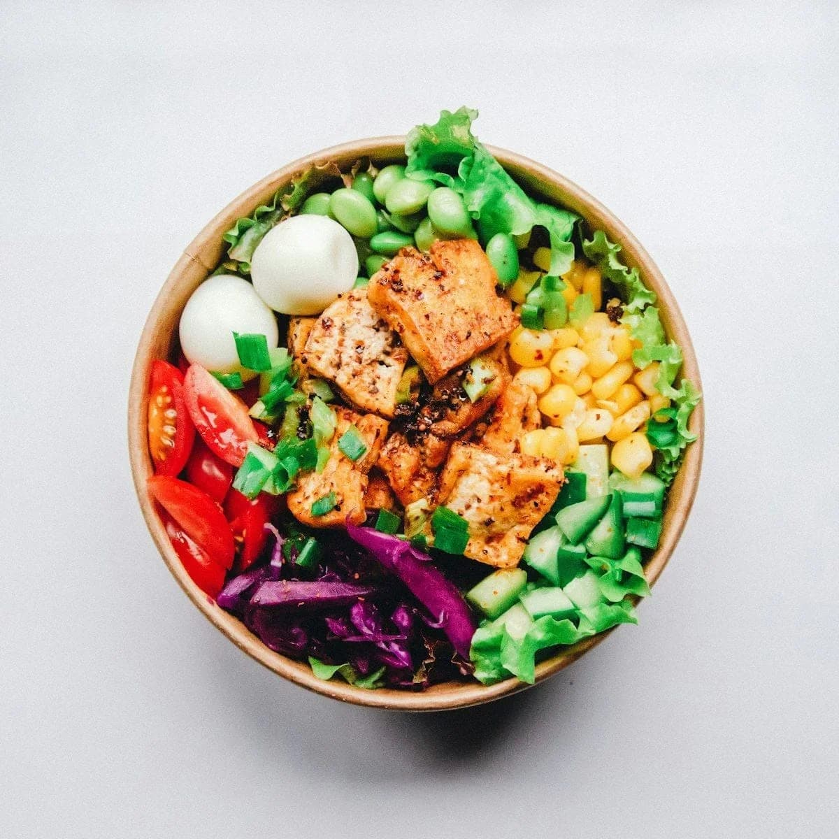 Colorful meal prep bowl with fresh vegetables, grains, and protein