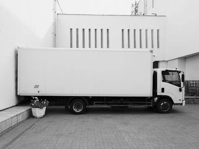 A white box truck parked near a building